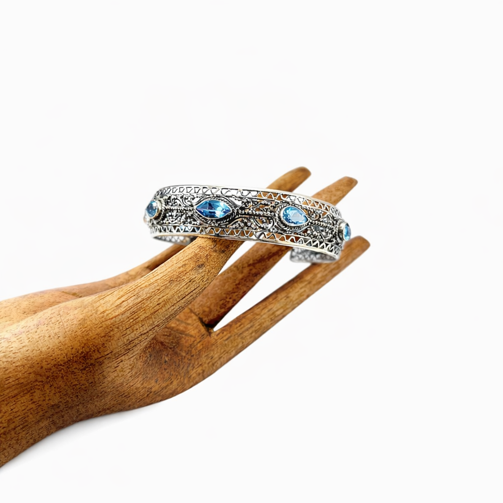 Artisan silver cuff bracelet featuring blue topaz gemstones